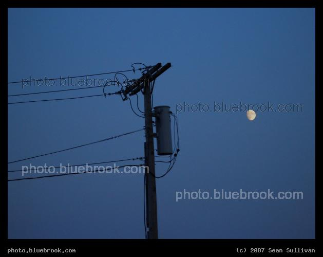 Electricity and Luminosity - The moon rising in evening twilight over Cambridge MA, next to a power line near MIT