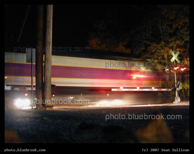 Passing Train - A time exposure of an MBTA commuter rail train passing through a street crossing in Needham MA