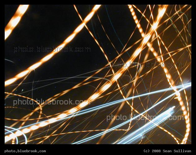 Strands of Light - A time exposure of passing streetlamps. The pulsing pattern is due to the alternating current on the power line making each light appear to cycle on and off 120 times per second, revealed here by the motion of the camera.