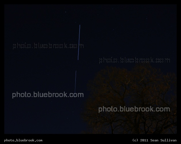 Completion - This 10-second exposure from Somerville MA shows the International Space Station (top line, trailing) in a finished configuration after the departure of space shuttle Discovery STS-133 (bottom line, leading), entering the Earth