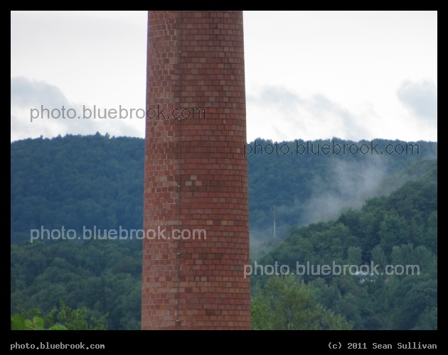 Brick Tower - An old smokestack, apparently not in use, West Lebanon NH.  The mountains in the background are in Vermont.
